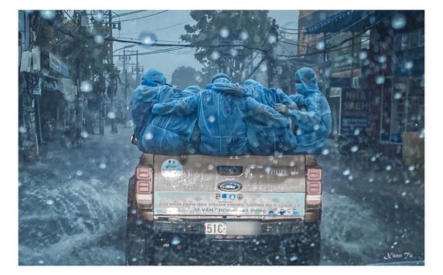 Đằng sau bức ảnh chiếc xe bán tải chở những áo xanh choàng vai dưới mưa tầm tã lay động triệu trái tim người Việt - Ảnh 2.